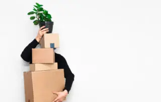Man with box moving in holding a plant