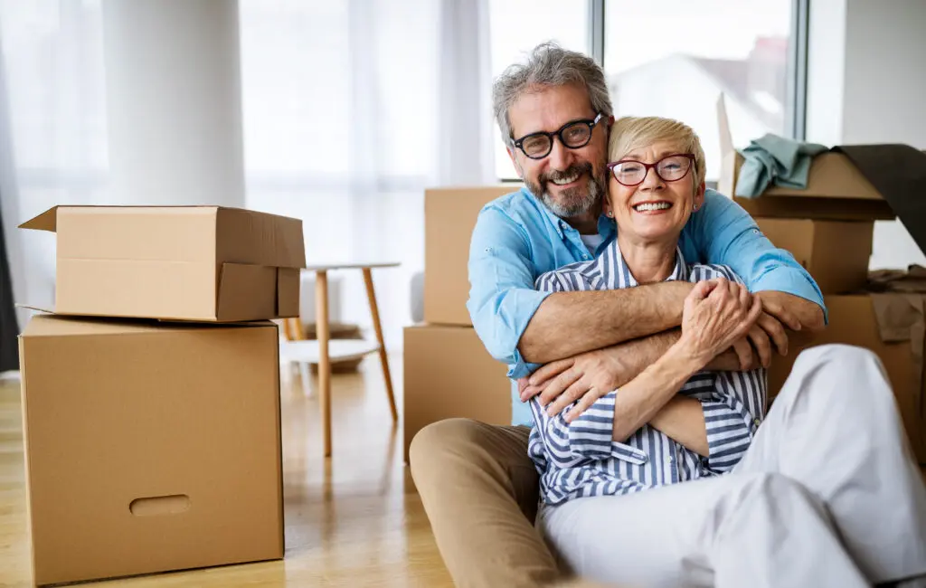 Portrait of happy smiling senior couple in love moving in new home and settling in