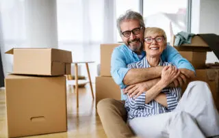 Portrait of happy smiling senior couple in love moving in new home and settling in