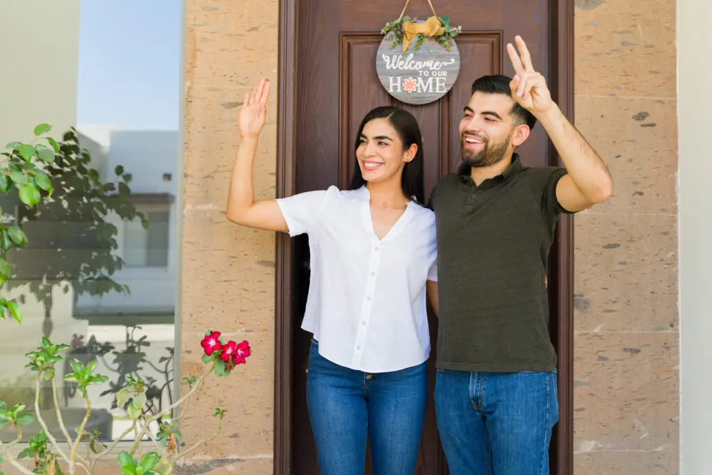 Young couple going out their house and waving and greeting some of her neighbors