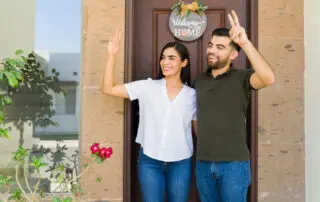 Young couple going out their house and waving and greeting some of her neighbors