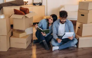 Notepad is in hands. Couple reviewing documents and planning their new home after moving.