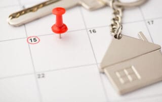 Overhead photo of label date 15 with inscription move house red pin and key with key ring as house isolated on the calendar background