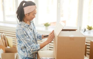 Woman labeling essentials kit moving box