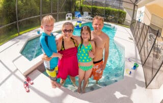 Happy Family playing in a backyard swimming pool in florida after a move.