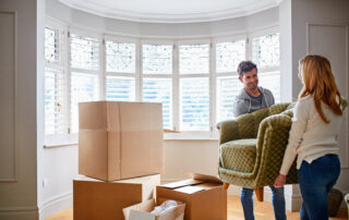 Carry, sofa and couple in new home for moving, packing furniture and relocation for real estate. Marriage, homeowner and man help woman with couch