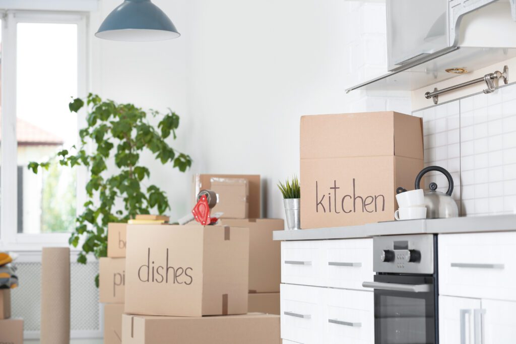 Cardboard boxes and household stuff in kitchen. Moving day